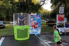 Ofc. Lang sitting in a dunk tank while local children attempt to dunk him